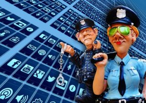 Two cartoon police officers stand in front of a wall of blue social media icons, symbolizing online security and monitoring.