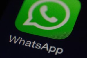 Green WhatsApp app icon with a white speech bubble and phone symbol on a dark background.