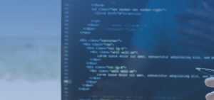 Close-up of a monitor showing blurred lines of code, with a hand holding a pen on the right edge.