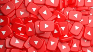 Pile of red square YouTube play button icons with white triangles filling the frame.