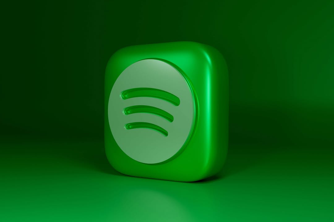 Green 3D cube with a white Spotify logo on its front, set against a matching green background.
